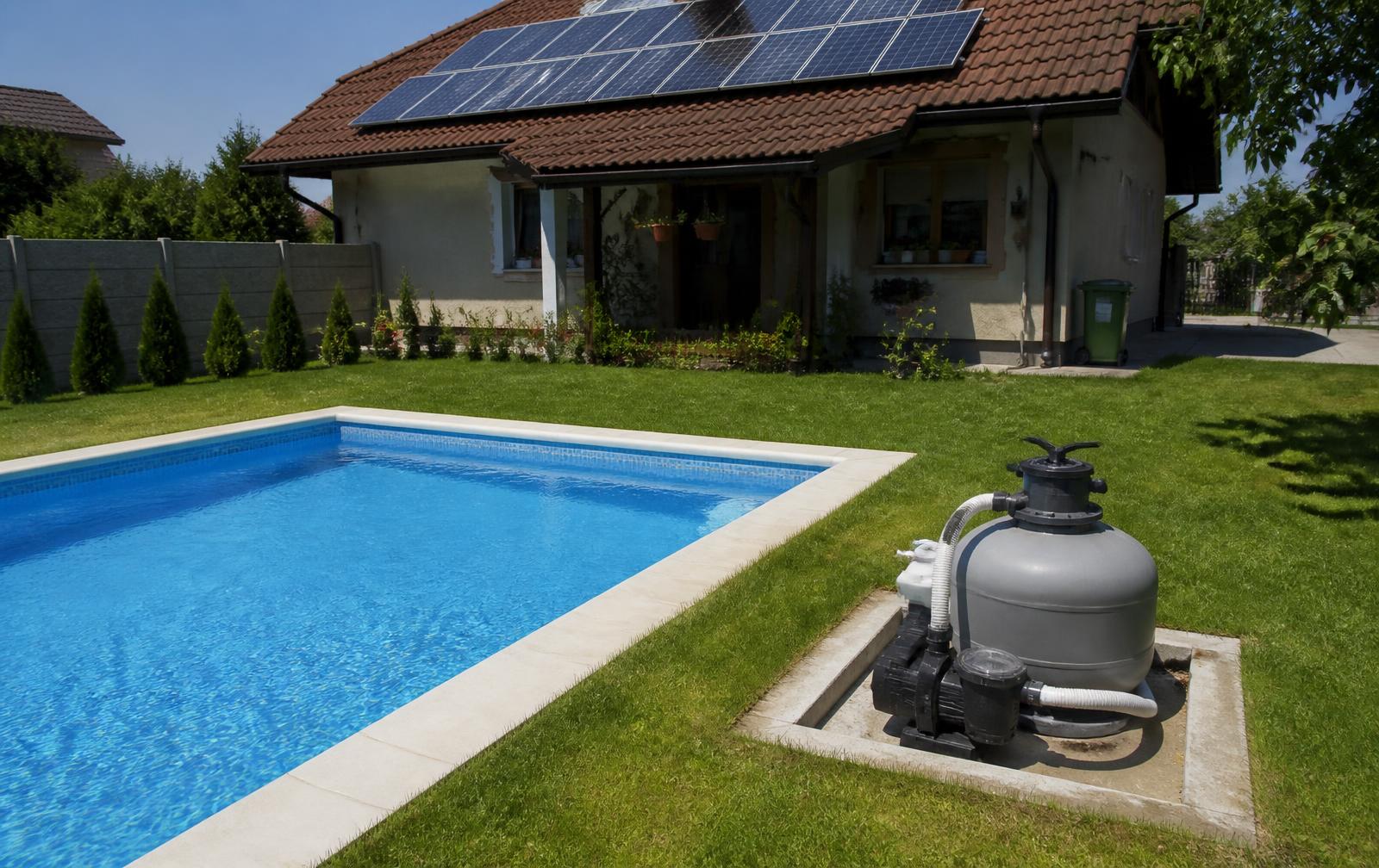 Grup de pompă și filtru cu nisip pentru piscină, instalat la sol lângă bazin, cu panouri fotovoltaice pe acoperișul casei